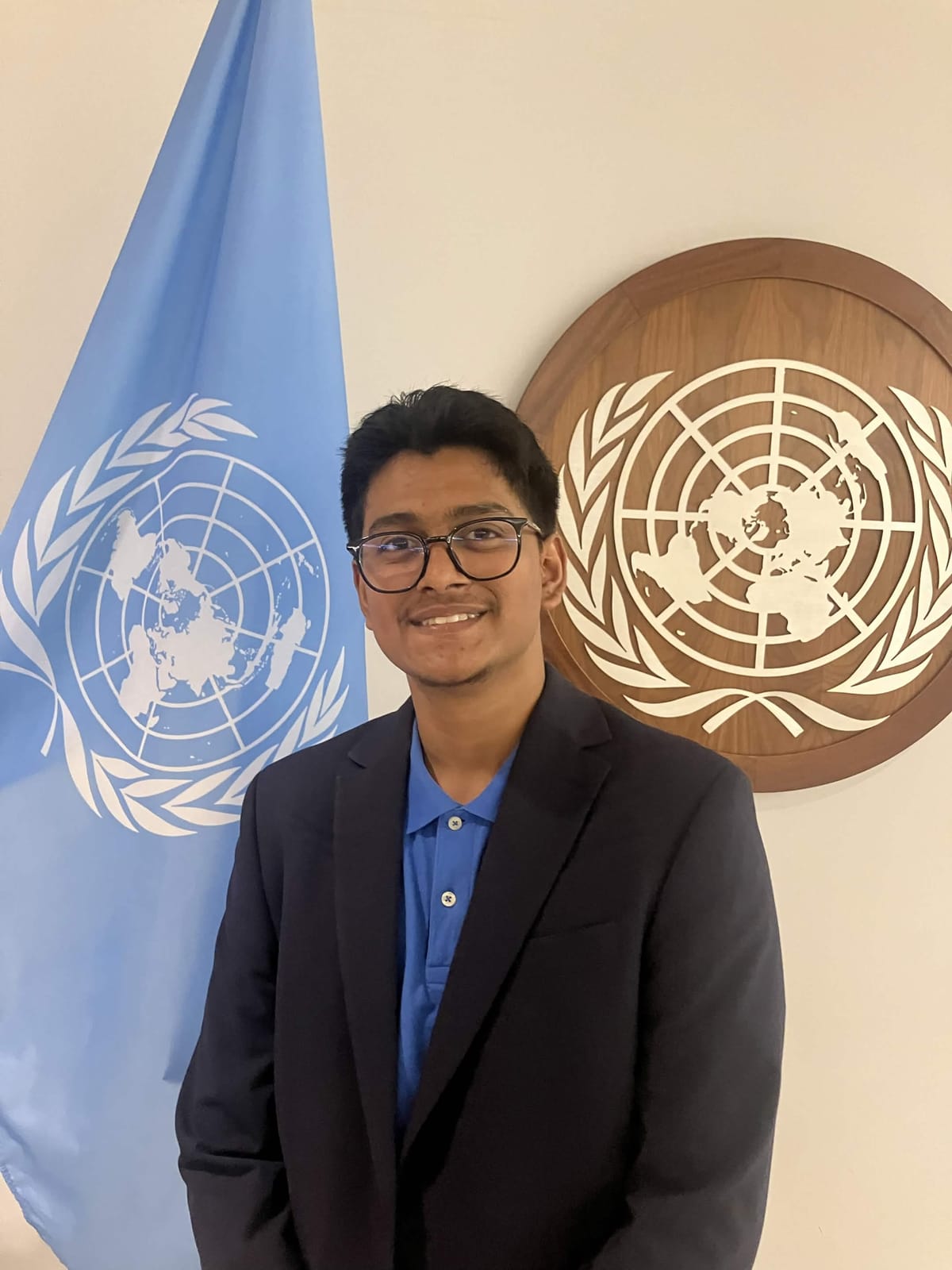 A DTC member beside the UN flag and emblem at the United Nations